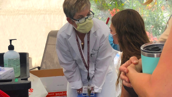 community health - nurse talking to girl with masks on